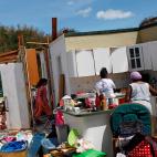 Miembros de una familia tratan de cocinar en lo que ha quedado de su casa.