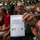Un hombre muestra una papeleta en el Tarraco Arena, Tarragona.