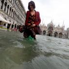 Una turista pasea por una inundada plaza de San Marcos en Venecia (Italia).