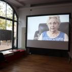 Una espectadora atiende el vídeo de la muestra.