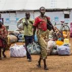 No ponto de coleta Elegu, uma família de refugiados carrega seus pertences antes da transferência para o campo Bidi Bidi. Ponto de coleta Elegu, 27 de outubro de 2016.