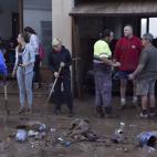 Vecinos de la localidad de Sant Lloren&ccedil; des Cardassar (Mallorca), limpian el lodo de sus viviendas, tras las inundaciones y el desbordamiento de torrentes.