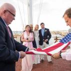 "El padre del novio falleció once años antes. Ellos hicieron ondear la bandera que ganó por ser un veterano de la Marina durante el banquete. Justo al atardecer, todos se reunieron mientras la novia, el novio y otros familiares cercanos la ar...
