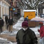 Un grupo de personas camina (como puede) por una calle nevada en el centro de Soria