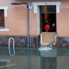 Vecinos tratan de frenar el agua para que no entre en sus casas.