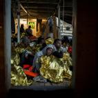Un grupo de hombres, procedentes de diferentes pa&iacute;ses del &Aacute;frica subsahariana, descansando en la cubierta del barco Golfo Azurro, un d&iacute;a despu&eacute;s de ser rescatados por la ONG Proactiva Open Arms. En el momento en el qu...