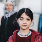 Retrato de una ni&ntilde;a refugiada en el puerto de la isla griega de Lesbos, minutos antes de coger el ferry junto a su familia, con destino a Atenas. Tras un breve paso por la isla, los refugiados trataban de llegar al norte del pa&iacute;s p...