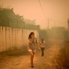 Dos mujeres se cubren la cara con un pa&ntilde;uelo para protegerse del humo en Torgal, Castanheira de Pera.