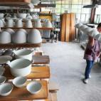 Una mujer trabaja en una planta de fabricación de porcelana cerca de Limoges, Francia, el 5 de julio de 2013. (MEHDI FEDOUACH/AFP/Getty Images)