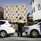 Oficial de la Policía Municipal acordona la zona de un nuevo edificio ocupado para dar refugio a 12 familias en el barrio de Torre Baró (Barcelona).