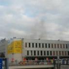 Humo negro sale de uno de los edificios principales del aeropuerto.