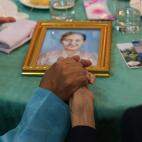 El surcoreano Choi Dong-gyu (dch), de 84 a&ntilde;os, da la mano a su sobrina la norcoreana Park Chun-hwa, 58 a&ntilde;os, ante las fotos de sus allegados.