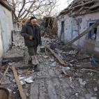Un vecino llamado Valery, camina entre los restos de su granja, da&ntilde;ada por un ataque en la ciudad de Tamarchuk, en Donetsk, el 20 de febrero.