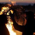 Dos chicas se ponen coronas de flores cerca de una fogata durante la celebración de la Noche de Iván Kupala en Minsk, Bielorrusia. La gente celebra esta noche con hogueras que duran toda la noche mientras saltan