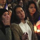 Una joven se limpia las lágrimas del rostro durante el momento de silencio de un homenaje en Sidney.