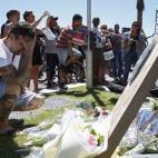Un hombre llora frente a las flores que se acumulan cerca del lugar del atentado, en Niza.