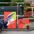 Frente a la embajada de Francia en Berlín (Alemania), una mujer deposita un ramo junto a dos cuadros que piden oraciones por Niza.