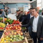 Feijóo comprobando el estado de varias piezas de fruta en una visita a la plaza de abastos de Portosín (Porto do Son, A Coruña).