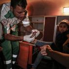 El personal médico ayuda a los civiles palestinos heridos después de que un edificio llamado "Hanady" en el barrio de Al-Rimal colapsara debido al ataque de aviones de combate israelíes en la Franja de Gaza