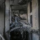 Los palestinos inspeccionan la torre Al-Jawhara, gravemente dañada, en la ciudad de Gaza después de que fuera golpeada por ataques aéreos israelíes en medio de la escalada de violencia israelí-palestina.