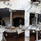 Dos mujeres miran lo que queda entre los escombros de su casa en Gaza.