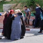 Mujeres palestinas reaccionan por la muerte de familiares fuera de un hospital en Beit Lahia en Gaza