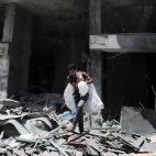 Un palestino camina sobre los escombros de la torre Al-Jawhara en la ciudad de Gaza