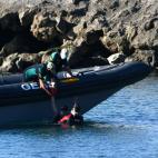 La Guardia Civil ayuda a los j&oacute;venes a subir a la lancha.