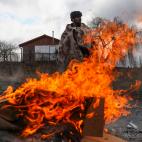 Un refugiado trata de calentarse con un fuego en la frontera ucraniano-polaca