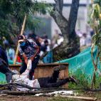 Dos manifestantes arrastran a un tercero, herido, tras una barricada.