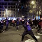 Un manifestante lanza una piedra en mitad de los disturbios