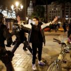 Un agente, a punto de reducir con la porra a un manifestante