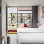 Altos techos adornados con farolillos, suelos cubiertos con baldosas ornamentadas y un vestíbulo con una escalera que serpentea hasta un entresuelo con balcón de cristal: así da la bienvenida al huésped el Generator Hostel de Barcelona. Este...