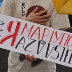 Una manifestante luce una pancarta en recuerdo de la acer&iacute;a Azovstal en Mari&uacute;pol