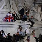 Personas subidas a la fuente frente al palacio de Buckingham.