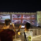 Una de las murallas de la Ciudad Vieja de Jerusalén, con las banderas israelí y británica proyectadas.