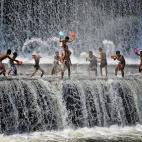Los niños juegan en una presa que se encuentra a lo largo del río Tukad Unda, en la región de Klungkung de Bali, Indonesia, en marzo de 2013. Algunas fotografías hacen que la presa parezca una cascada natural. La gente de la localidad se b...