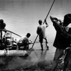 Los habitantes de un pueblo cercano a una presa de Theun Hinboun ponen en marcha una bomba de agua para regar nuevos campos localizados en una colina lejana del margen del río, en Laos en el año 2008.