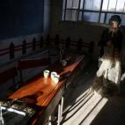 Esta chica, que lleva las ropas tradicionales de los hombres, pliega ropa durante la celebración de final de curso en un colegio de Duma, en Damasco.