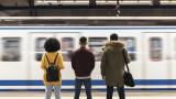 Tres personas esperando al Metro de Madrid.