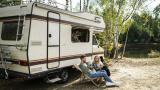 Familia relajándose en una autocaravana en un camping.