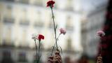 Varias personas sujetan flores durante una manifestación de Marea de Residencias