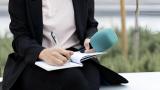 Una periodista anotando cosas en su cuaderno