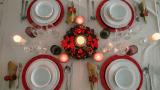 Mesa de Navidad con decoración clásica, bajoplatos rojos y cubertería colocada para la cena de Nochebuena.