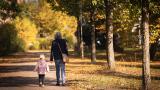 Una abuela paseando con su nieta de la mano en un parque