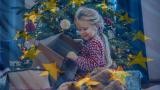 Una niña descubre sus regalos de Navidad bajo el árbol, rodeada de estrellas de la bandera de la UE.