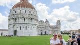 Una pareja de jubilados haciéndose una foto en la Catedral Católica de Pisa
