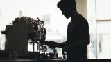 Un joven camarero prepara un café en un bar