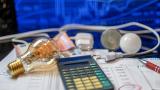 Una factura de la luz rodeada de una calculadora, varios billetes y una bombilla.