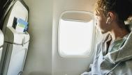 Mujer mirando por la ventanilla en el avión
